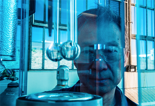 Researcher Hoon Chung stands behind a Quantachrome Instruments gas sorption analyzer, which measures the surface area and pore-size distribution in fuel cell electrocatalysts.