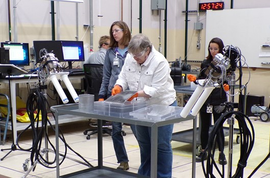 Mary Hockaday, NEN Division Leader, stacks polyethylene plates and uranium foils during a hands-on experiment used to demonstrate the effects of moderators and reflectors on fissile material operations.