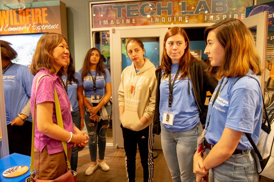 Elizabeth Hong-Geller (B-DO), left, talks with JSTI students during their visit to the Bradbury Museum.