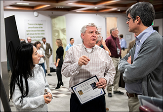 JiaJia Waters, left, and David Carrington, center, led the R&D 100 Award winners entry, FEARCE.  Here they talk about their software system technology to Lab Director Thom Mason during the Lab's R&D 100 award ceremony. 