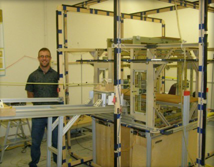 Derrick Kaseman is shown here with the instrumentation. Measurements are made by pre-polarizing the sample in a secondary permanent magnetic field to boost signal intensity and rapidly moving the sample (in less than one second) to the Earth’s magnetic field for detection.