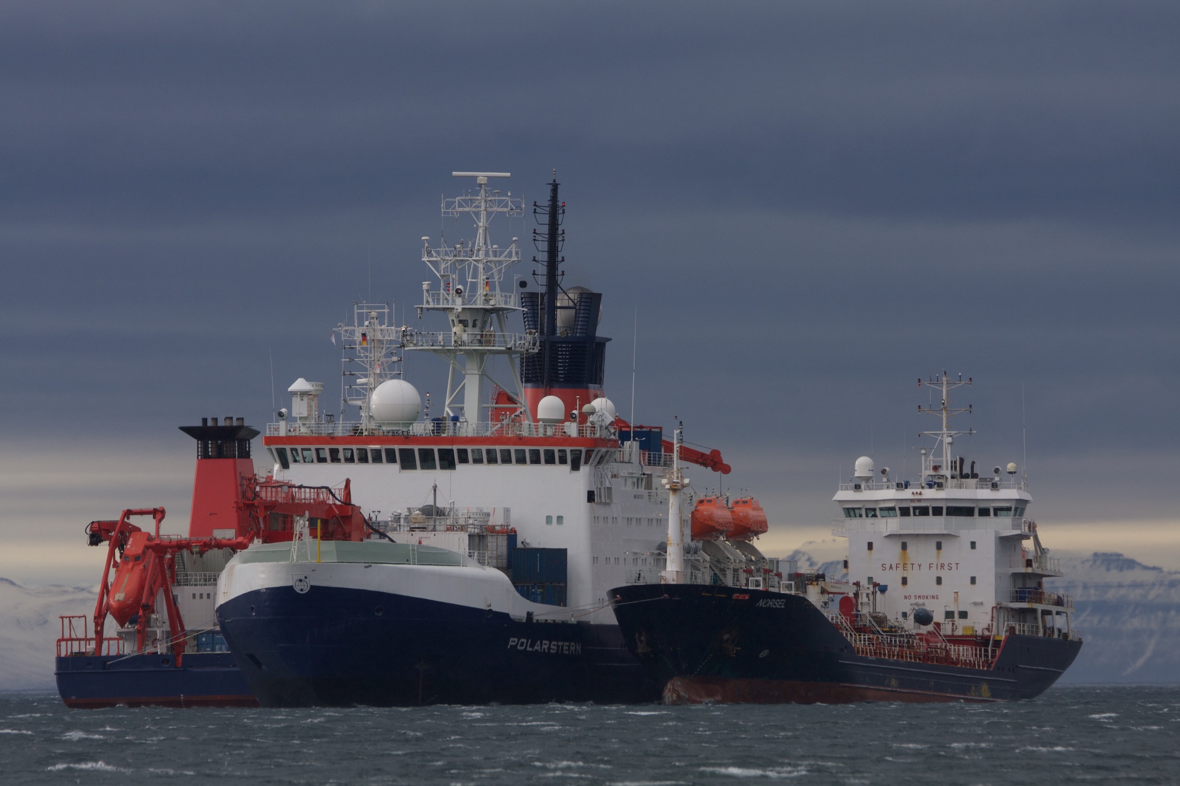 The R/V Polarstern (left) helps carry out the crew exchange and supply delivery for MOSAiC Leg 4 in early June 2020 near Svalbard, Norway. Photo credit: Leonard Magerl, Alfred Wegener Institute.